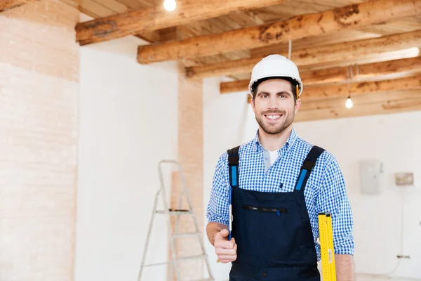 Construtor de pé e segurando ferramentas no local de trabalho — Fotografia de Stock