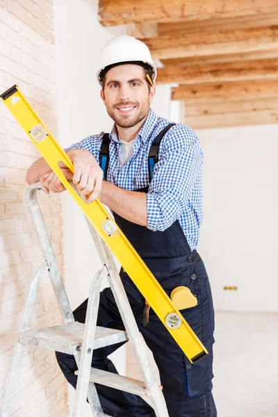 Close-up portrait of a smiling worker holding level — Stock Photo, Image