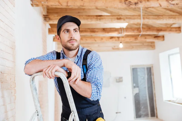 Gutaussehender Bauunternehmer, der bei der Arbeit an etwas denkt — Stockfoto