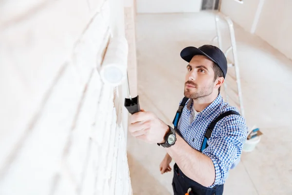 Ritratto ravvicinato di un decoratore con rullo durante il lavoro — Foto Stock