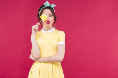 Komik güzel pinup kız bir gözü sarı lolipop ile kaplı