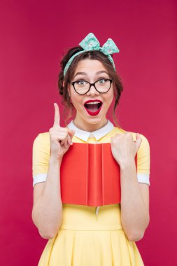 Woman with red book pointing up and having an idea