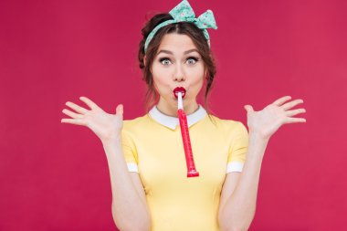 Kız parti düdük üfleme ve avuç içi üzerinde copyspace tutarak