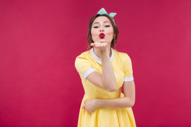 Sevimli sevimli genç kadın ayakta ve bir öpücük gönderme