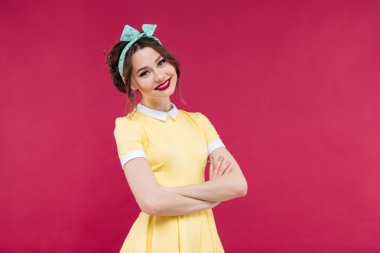 Gülümseyen genç kadın kolları ile duran sarı elbiseli geçti