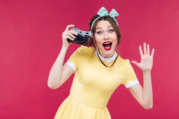 Vrolijke pinup meisje met vintage camera en nemen van foto 's — Stockfoto