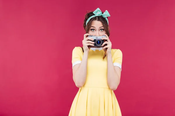 Leuke mooie jonge vrouw bedekt haar gezicht met oude camera — Stockfoto