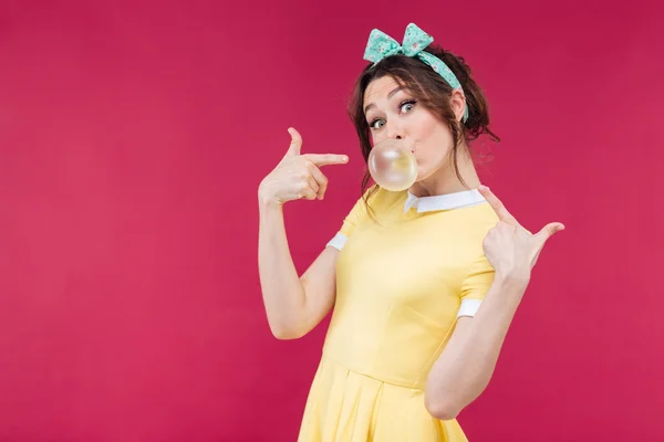 Playful charming young woman pointing on bubble gum balloon — Stock Photo, Image