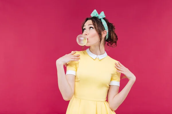 Thoughtful attractive young woman blowing bubble from chewing gum — Stock Photo, Image