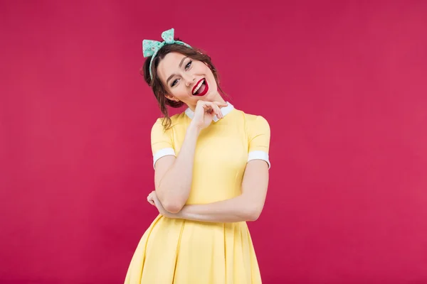 Alegre bela pinup menina em amarelo vestido de pé e smili — Fotografia de Stock