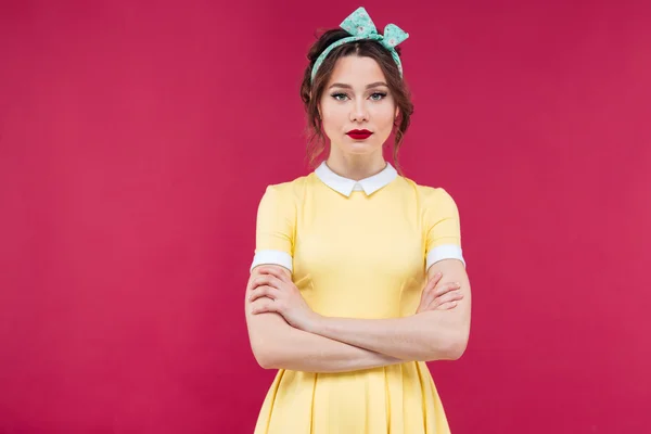 Bela mulher séria em vestido amarelo de pé com braços cruz — Fotografia de Stock