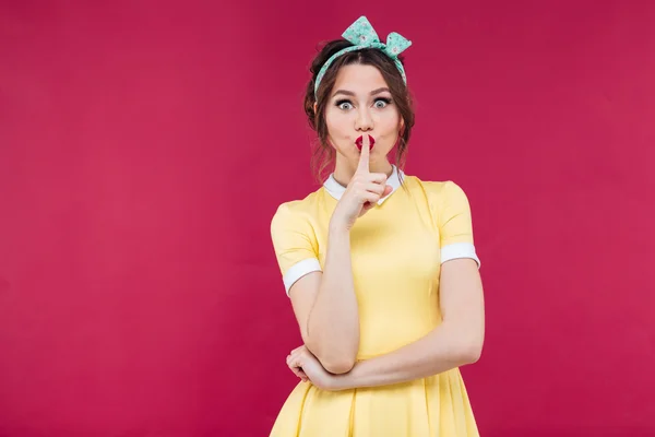 Hermosa chica linda pinup en vestido amarillo mostrando señal de silencio — Foto de Stock