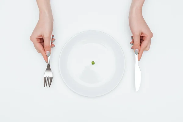 Mujer comiendo un pequeño guisante verde con cuchillo y tenedor —  Fotos de Stock