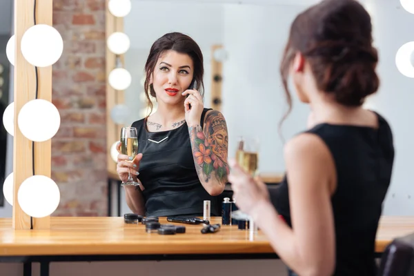 Vrouw champagne drinken en praten over telefoon in kleedkamer — Stockfoto