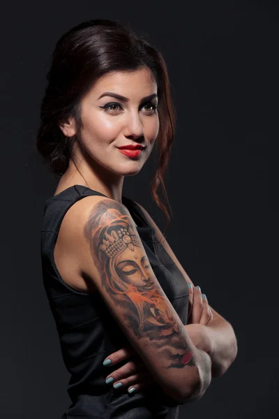 Mooie tattoed jonge vrouw met gevouwen handen — Stockfoto