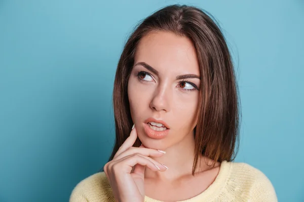 Gros plan portrait de fille coûteuse réfléchissant sur fond bleu — Photo