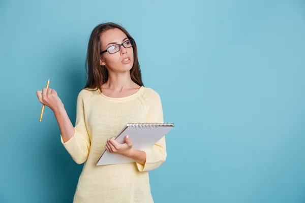 Giovane intelligente ragazza pensierosa pensando a qualcosa che tiene raccoglitori colorati — Foto Stock