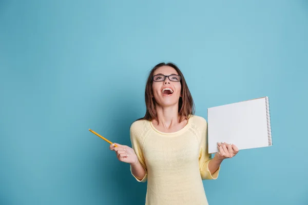 Rindo menina segurando notebook sobre fundo azul — Fotografia de Stock