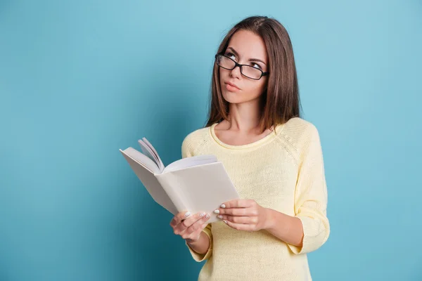 Nadenkend slim meisje denken over iets ingedrukt te boek — Stockfoto