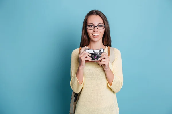 파란색 배경 위에 photocamera를 사용 하 여 사진을 복용 하는 젊은 예쁜 여자 — 스톡 사진