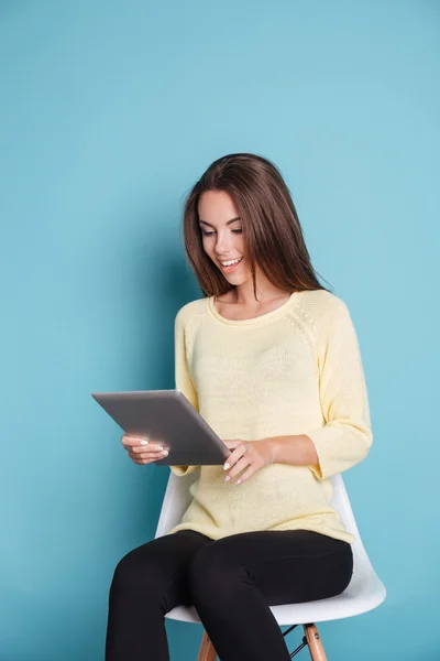 Mujer joven sonriente mirando la tableta — Foto de Stock