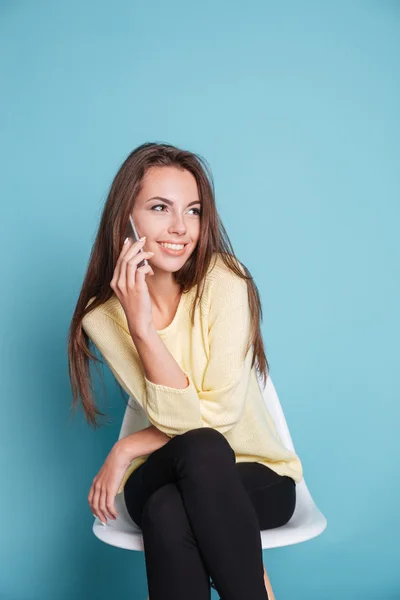 Mujer hablando en el teléfono inteligente sobre fondo azul — Foto de Stock