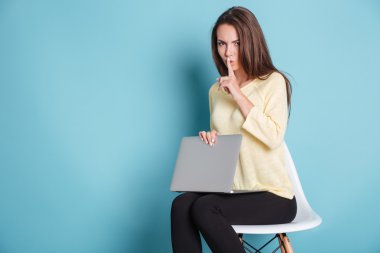 Dizüstü bilgisayar kullanarak sessizlik jest yapma ciddi güzel kadın