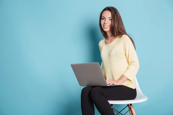 Sorridente bella adolescente con computer portatile pc su sfondo blu — Foto Stock