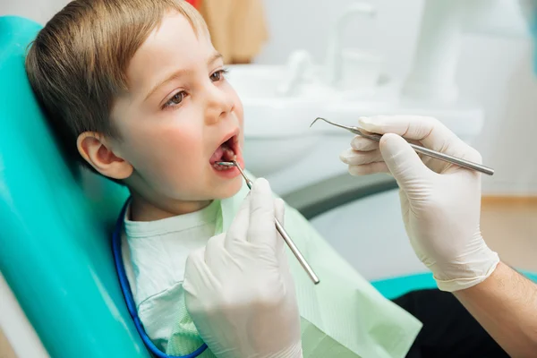 Jongen zit met mond geopend tijdens de mondelinge checkup op tandarts — Stockfoto