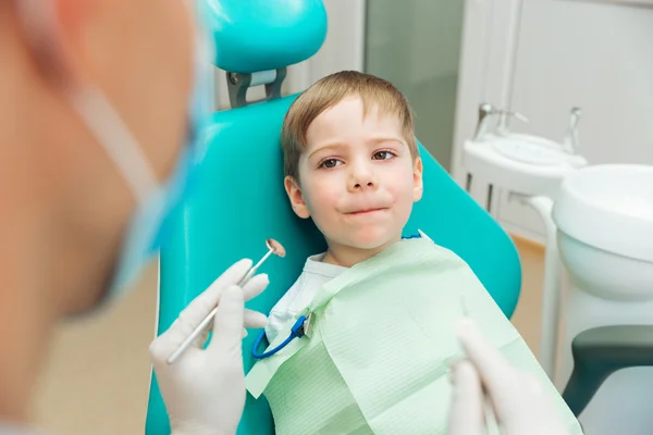 Испуганный мальчик сидит с закрытым ртом в стоматологической клинике — стоковое фото