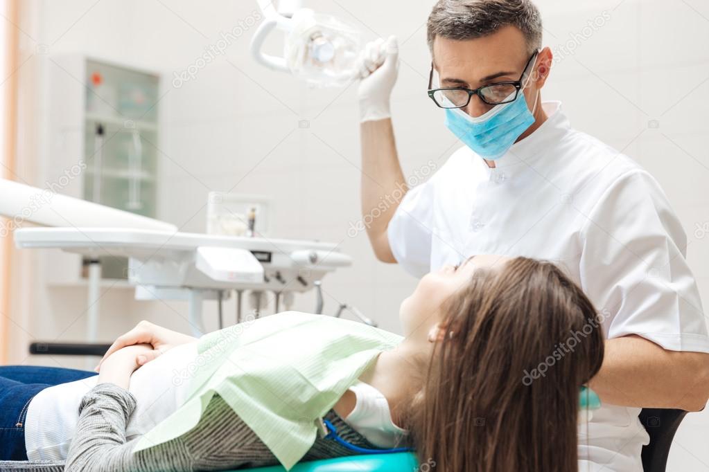 Dentista muy cuidadosamente comprobar y reparar los dientes a los
