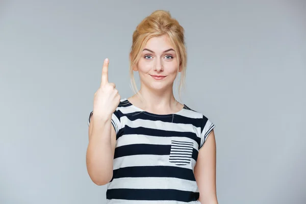 Glada charmig ung kvinna visar ett finger och pekar uppåt — Stockfoto
