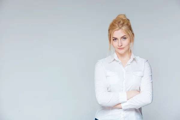 Serious pretty young businesswoman standing with arms crossed — Stock Photo, Image