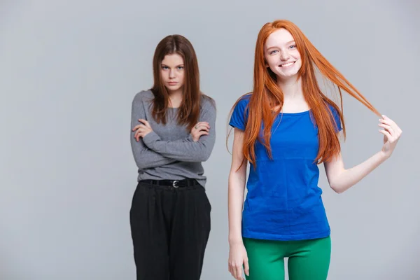 Deux rousses souriantes et jeunes femmes brunes bouleversées — Photo