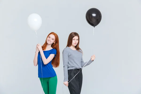 Две молодые женщины держат черно-белые шарики — стоковое фото
