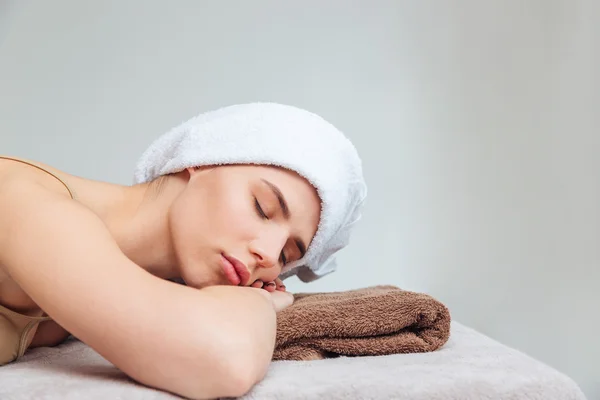 Beautiful young woman lying with eyes closed in spa salon — Stock Photo, Image