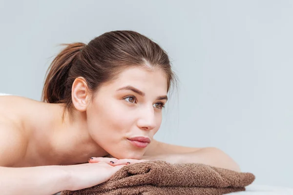 Relajada linda mujer joven acostada en la toalla en el salón de spa —  Fotos de Stock