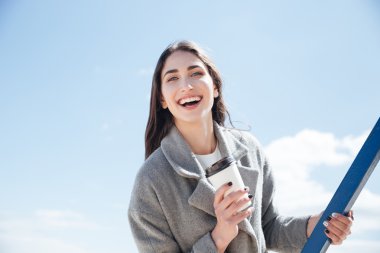 Take away Kupası tutan genç gülümseyen kız portresi