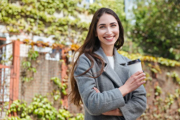 Leende vackra glada tjej håller take away kaffe — Stockfoto