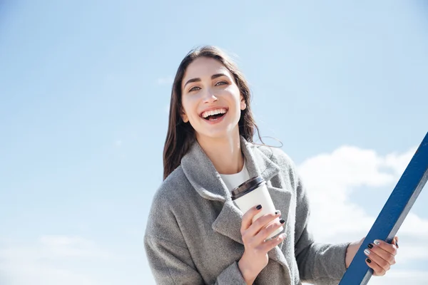 Retrato de una joven sonriente sosteniendo una taza para llevar —  Fotos de Stock