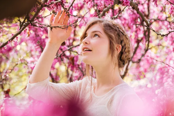 Adorável jovem no jardim da primavera com árvores florescentes — Fotografia de Stock