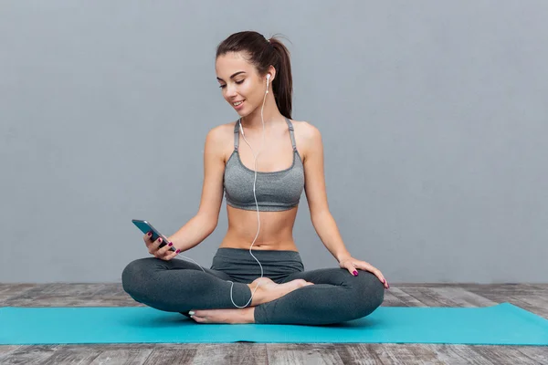Young woman listening to music in yoga outfit — Stock fotografie