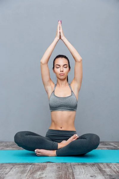 Ung kvinna gör yoga övning padmasana (lotus pose) — Stockfoto