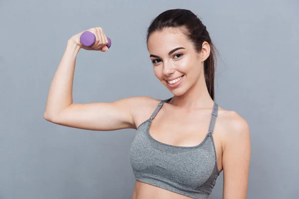 Beautiful smiling girl standing with dumbbells — Stockfoto