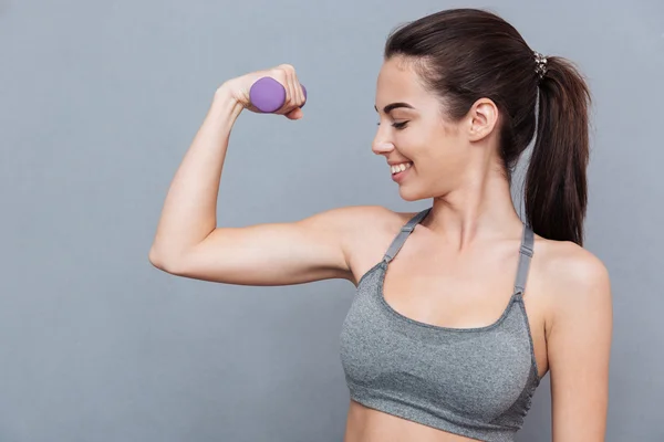 Mooi meisje staande met dumbbells en glimlachend — Stockfoto