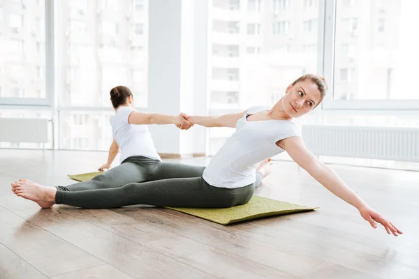 Дві жінки розтягуються і розслабляються в центрі йоги — стокове фото
