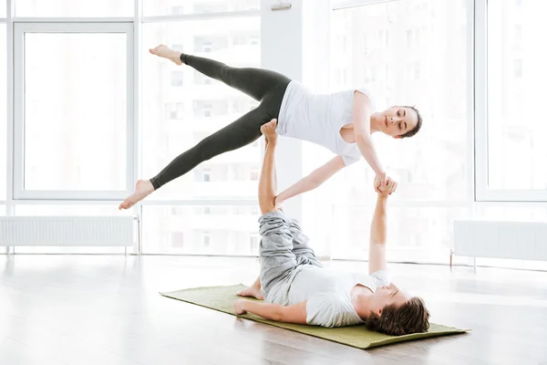 Mulher atraente alongamento e fazendo acro ioga com parceiro — Fotografia de Stock