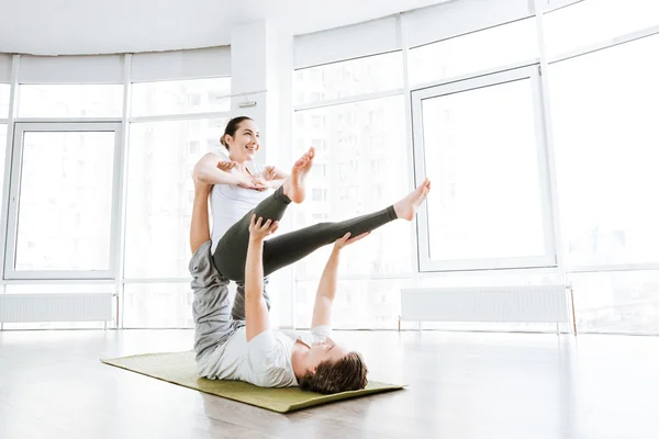 Coppie sorridenti che praticano esercizi di acro yoga — Foto Stock