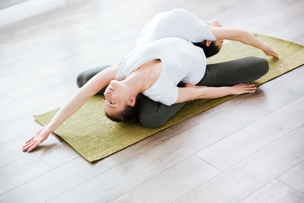 Two women practicing yoga in studio