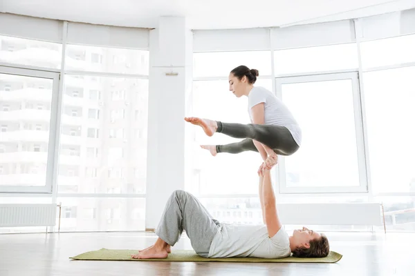 Uomo e donna che fanno acro yoga in coppia — Foto Stock